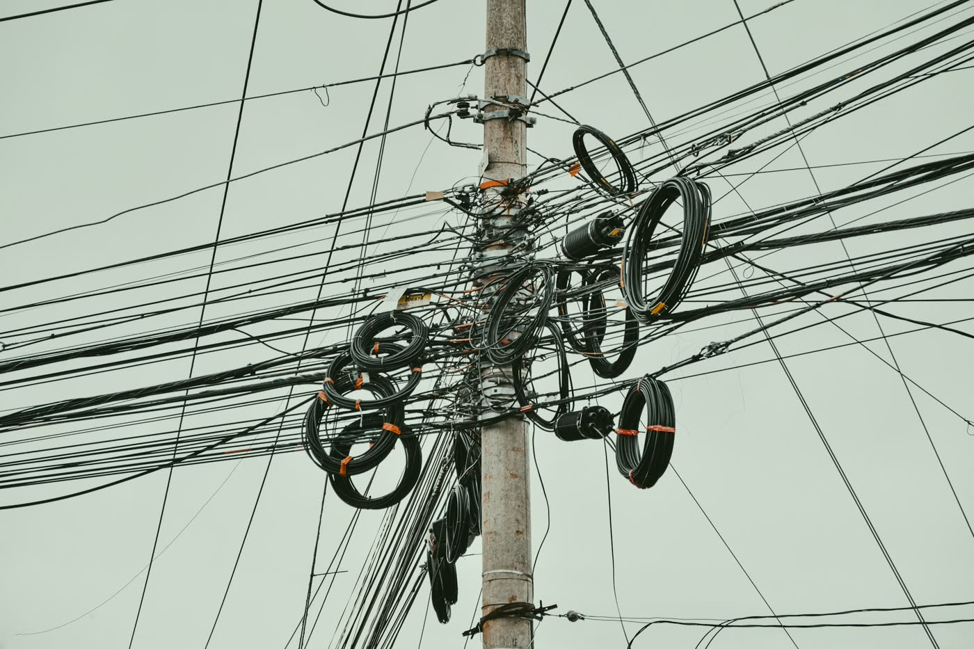 Coiled fibre and cables on a utility pole against the sky